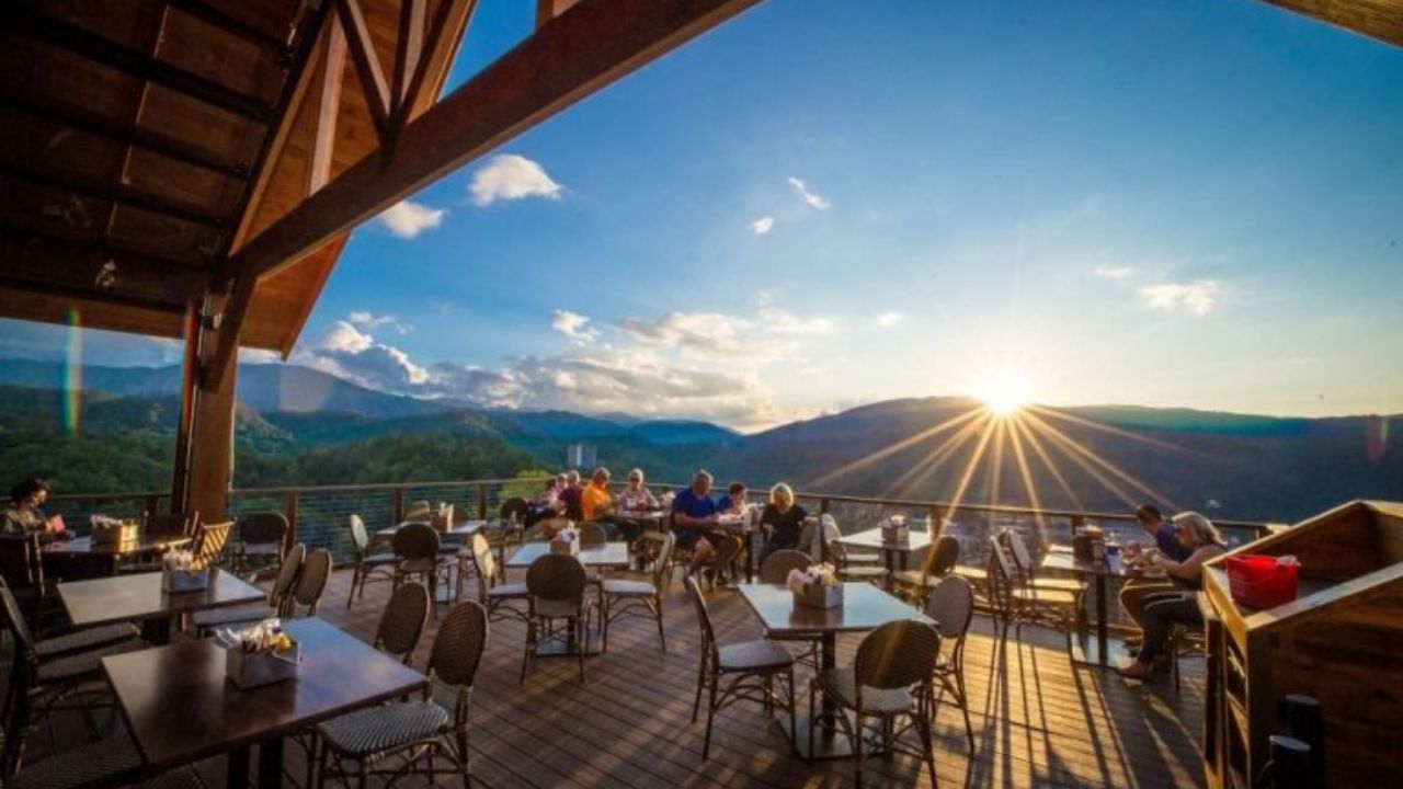 An outdoor dining area in Gatlinburg with tables overlooking a scenic mountain vista.