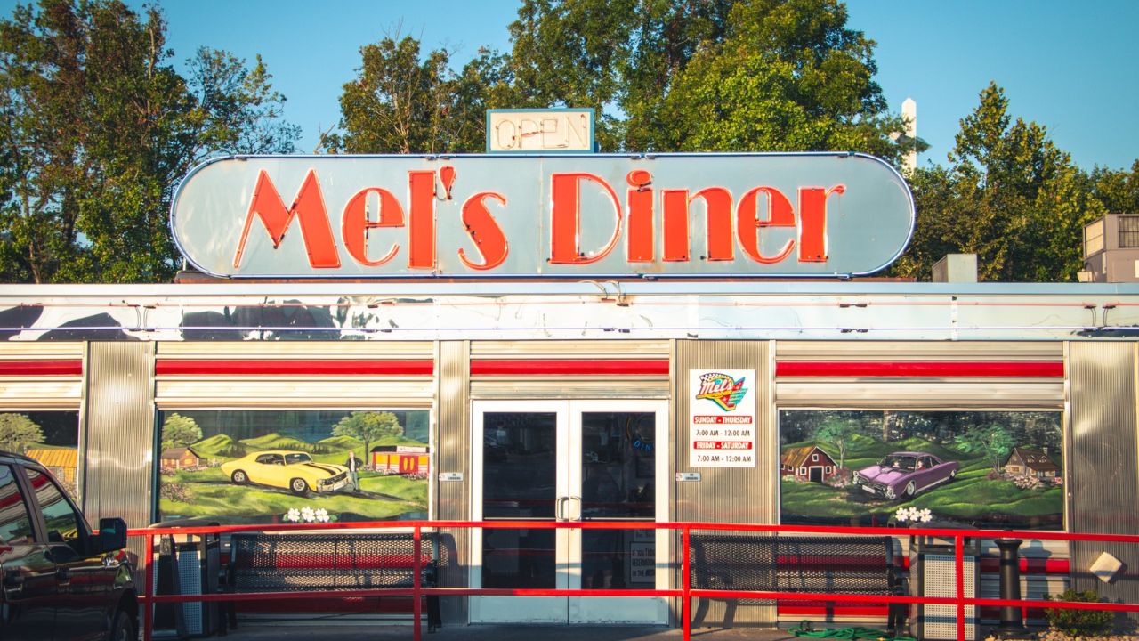 The exterior of a bustling diner in Pigeon Forge with a retro sign.