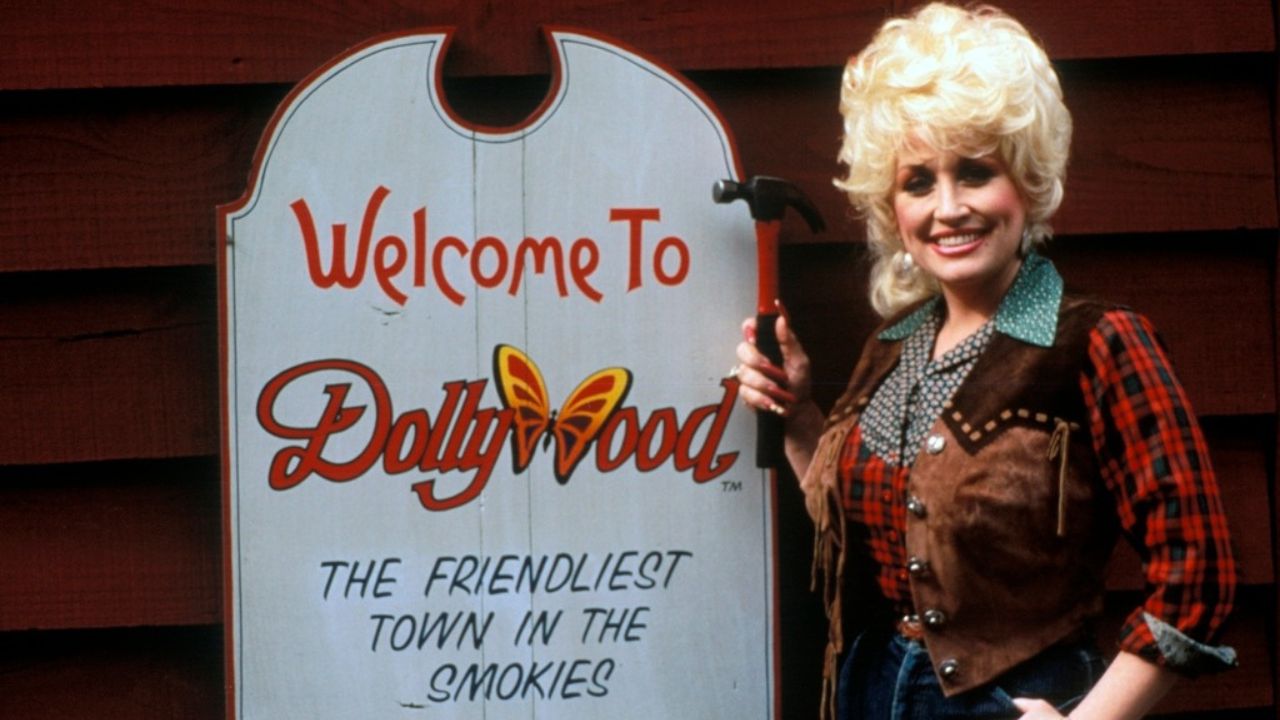 Dolly Parton posing for a portrait at Dollywood in her iconic country music attire from the past.